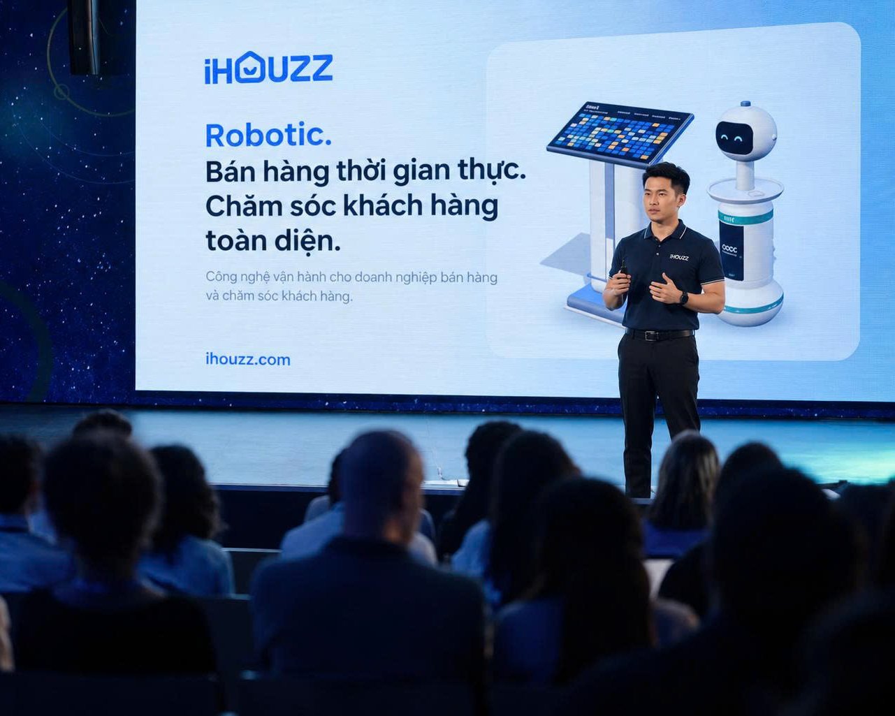 Lãnh đạo iHouzz trình bày trên sân khấu trước khán giả, màn chiếu giới thiệu Robotic, Bán hàng thời gian thực, Chăm sóc khách hàng toàn diện